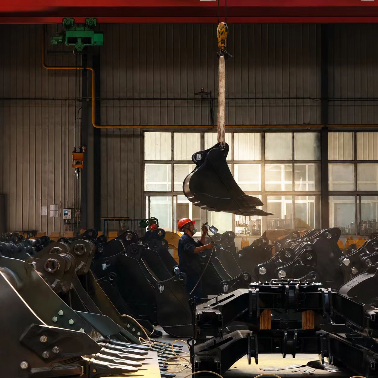 Excavator attachments and buckets staged inside the TOUGHNEER factory